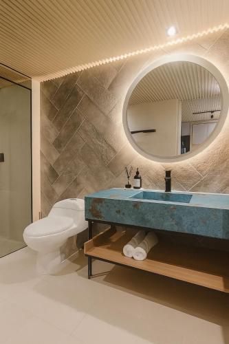 a bathroom with a sink and a toilet and a mirror at Coral Confort APTS San Andres in San Andrés