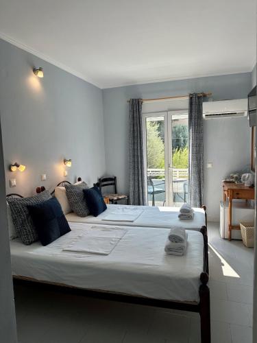 a bedroom with two beds and a large window at Hotel Lenox in Pythagoreio