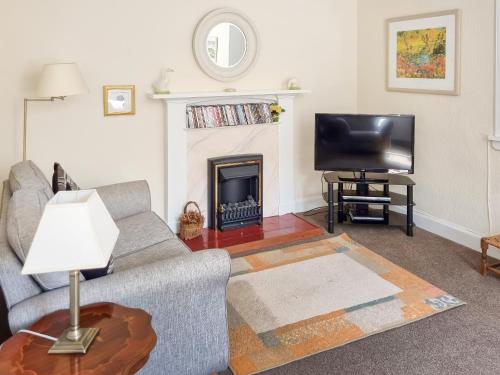 a living room with a couch and a fireplace at The Coach House in Girvan