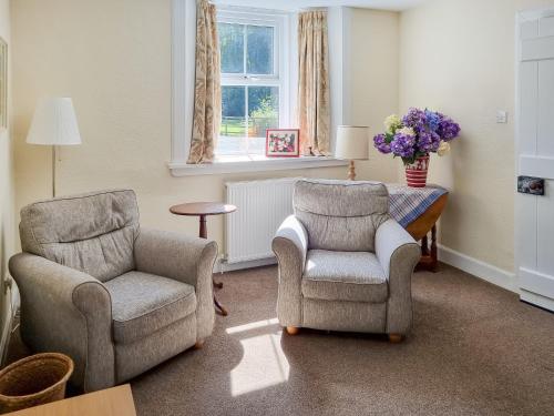 a living room with two chairs and a chair and a table at The Coach House in Girvan