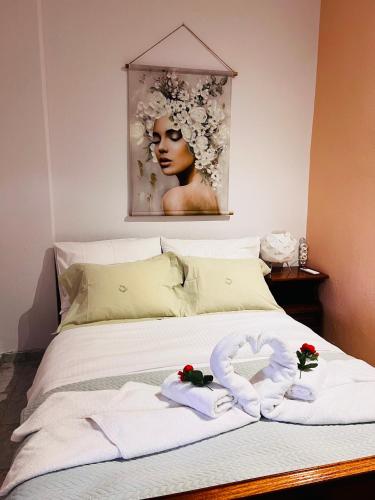 a bed with towels and a picture of a woman at Quiet Mountain View Retreat Helicon, Kyriaki in Kiriákion