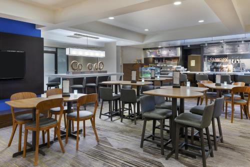 a restaurant with tables and chairs and a bar at Courtyard Mobile in Mobile