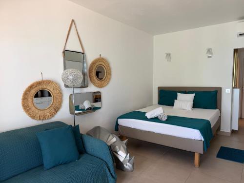 a bedroom with two beds and a couch at Residence Anse des sables in Marigot