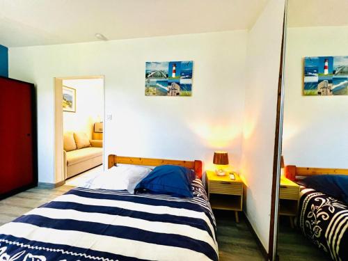 a bedroom with a bed and a mirror at Petite maison Cosy Le gaucher in Muret
