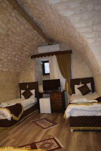 a bedroom with two beds and a desk in a room at JOSELİN HOTEL in Urfa