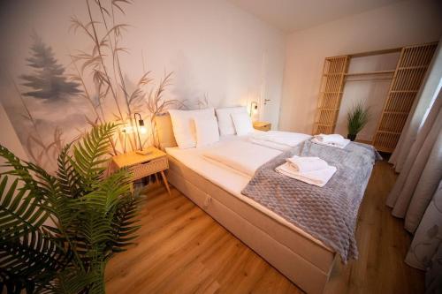 a bedroom with a bed and a plant in it at Boho vibes between mountains and lakes in Schlier