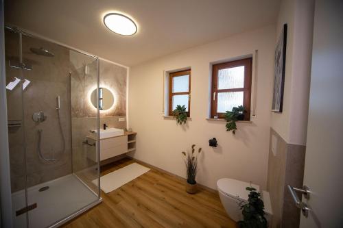 a bathroom with a shower and a sink and a toilet at Boho vibes between mountains and lakes in Schlier