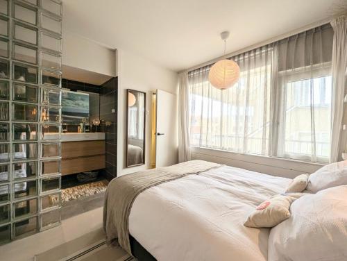 a bedroom with a large bed and a large window at Strandstudio Lumare in Bergen aan Zee