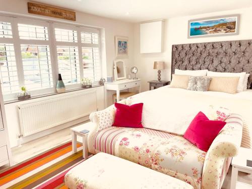 a bedroom with a large bed and a couch at Jayslin in Felpham