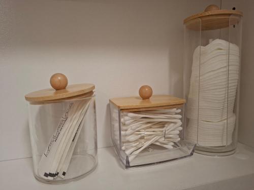 two glass containers with wooden tops on top of them at Luna apartman in Čačak