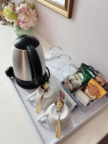 a tea kettle and spoons on a tray on a counter at Hanover House in Edinburgh