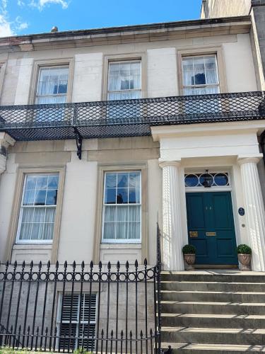 a white house with a green door and stairs at Hanover House in Edinburgh