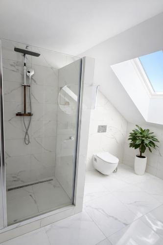 a white bathroom with a shower and a toilet at Hotel Sebastian u Hoffera in Modra