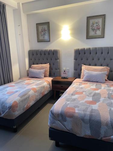 two beds sitting next to each other in a bedroom at Departamento bellísimo a 10 minutos de la playa in Nuevo Vallarta