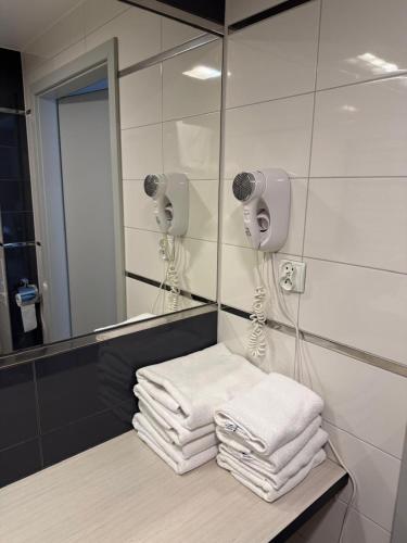 a pile of towels on a counter in front of a mirror at Apartament Rajka in Biała Woda