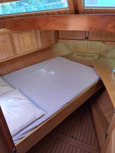 a small bed in the middle of a boat at Bleu soleil in Dieupentale