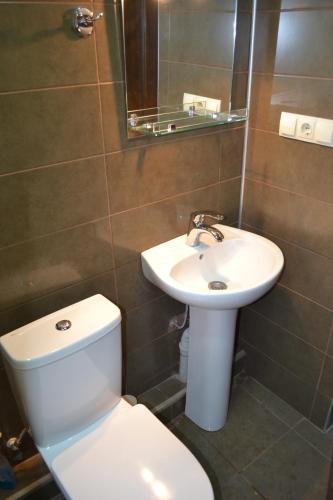 a bathroom with a white toilet and a sink at Iceberg Loft in Gudauri