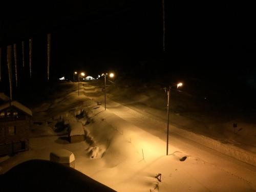 a group of people skiing down a snow covered slope at night at Iceberg Loft in Gudauri