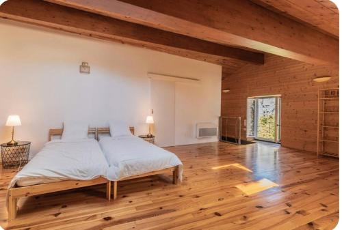 a bedroom with a large bed in a room with wooden floors at Villa Marisa in Ax-les-Thermes