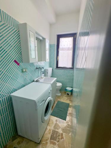 a bathroom with a washing machine and a toilet at Sotto i Monti House in Nicolosi