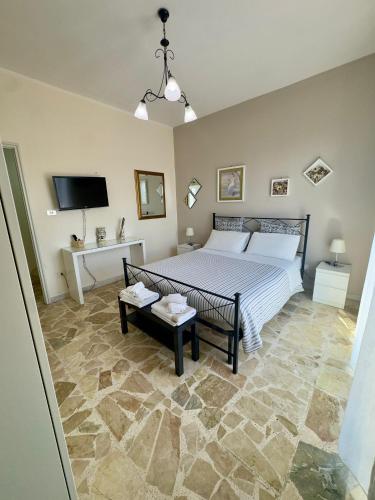 a bedroom with a bed and a tv in it at Sotto i Monti House in Nicolosi