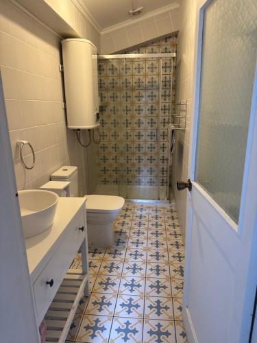 a bathroom with a toilet and a sink and a shower at Relaxing house by the beach - Casa Rosa in Horta