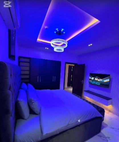 a purple bedroom with a bed and a purple ceiling at De Crystal Place in Ikate