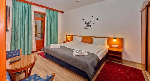 a hotel room with a bed and a table at Muskatli Villa in Sovata