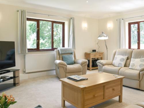 a living room with two chairs and a coffee table at The Oaks - Uk11270 in Lanreath