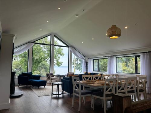 a dining room with a table and chairs and windows at Lough View Lodge in Ballyronan