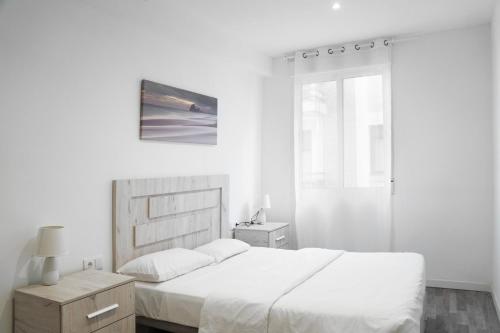 a white bedroom with a bed and a window at Ecos del Mar - Darya in Peniscola