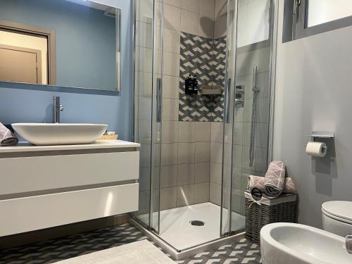 a bathroom with a glass shower and a sink at Agordo Suite in Agordo