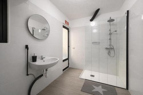 a white bathroom with a sink and a shower at Alicante Beach Hostel in Alicante