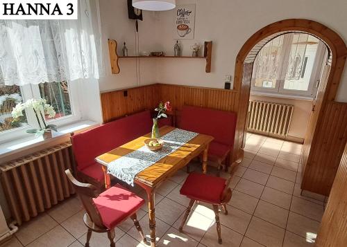 a dining room with a table and red chairs at Hanna 3 Apartman in Kőszeg