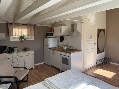 a kitchen with white cabinets and a white refrigerator at Guest House Stare in Strömstad