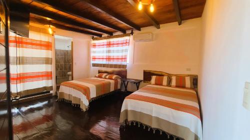 a bedroom with two beds and a window at Casa Bugambilia in Paso Hondo