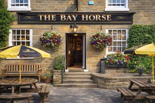 a building with tables and umbrellas in front of the bay horse at The Bay Horse Country Inn in Thirsk