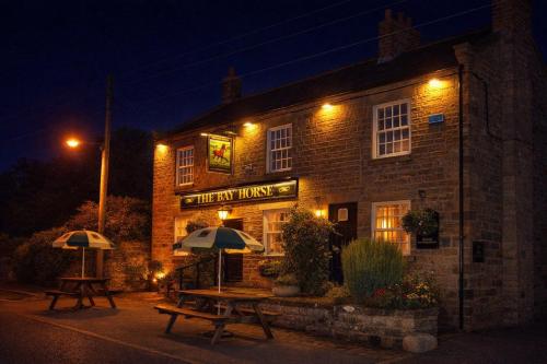 two picnic tables in front of a building at night at The Bay Horse Country Inn in Thirsk