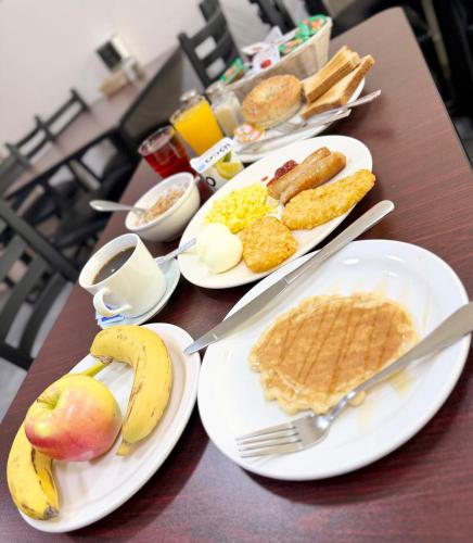 a table with plates of breakfast food on it at Howard Johnson by Wyndham Fort St. John in Fort Saint John