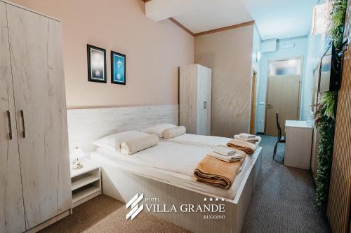 a bedroom with a large white bed with towels on it at HOTEL Villa Grande in Bugojno