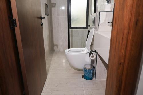 a bathroom with a white toilet and a sink at رست للشقق المخدومة in Medina