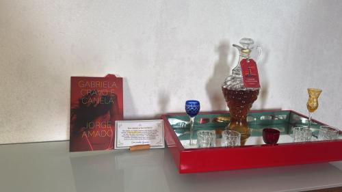 a shelf with a bottle and glasses on it at Hospedagem no Farol da Barra in Salvador