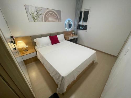 a bedroom with a large white bed with red pillows at Homestay THAIPHONG DRAGON CASTLE Bãi Cháy in Ha Long