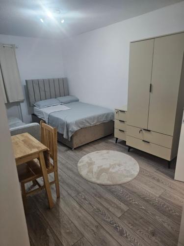 a bedroom with two beds and a table and a cabinet at Rose Acre Home Basildon in Basildon