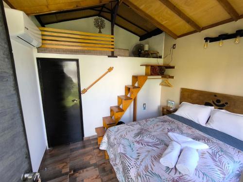 a bedroom with a bed with white pillows and a staircase at Aldea Xochi cabañas in Chiconcuac