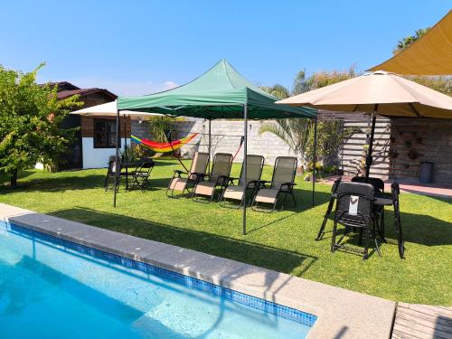 a group of chairs and umbrellas next to a pool at Aldea Xochi cabañas in Chiconcuac