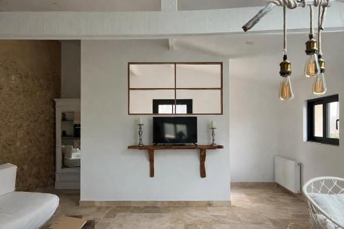 a living room with a tv on a wall at La bergerie des petits loups in Montagnac-la-Crempse
