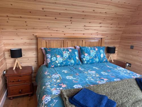 a bedroom with a bed and a wooden wall at Dalrigh Pod 2 in Onich