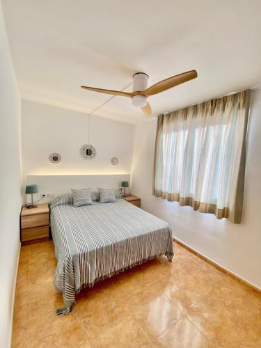 a bedroom with a bed and a ceiling fan at Alma Marina Alcossebre - WiFi - Pet friendly - Aire Acondicionado in Alcossebre