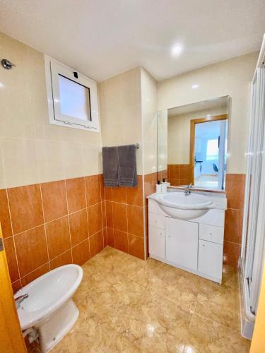 a bathroom with a white toilet and a sink at Alma Marina Alcossebre - WiFi - Pet friendly - Aire Acondicionado in Alcossebre